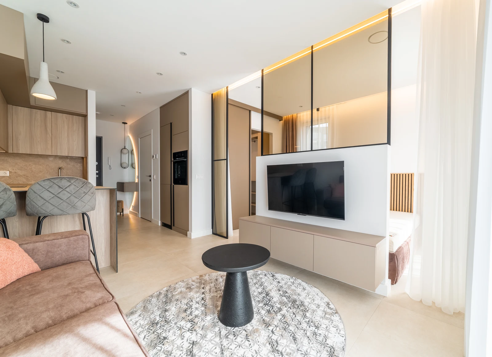 The completed highlighted apartment, with fitted kitchen, living area, bespoke storage and glazed partition.